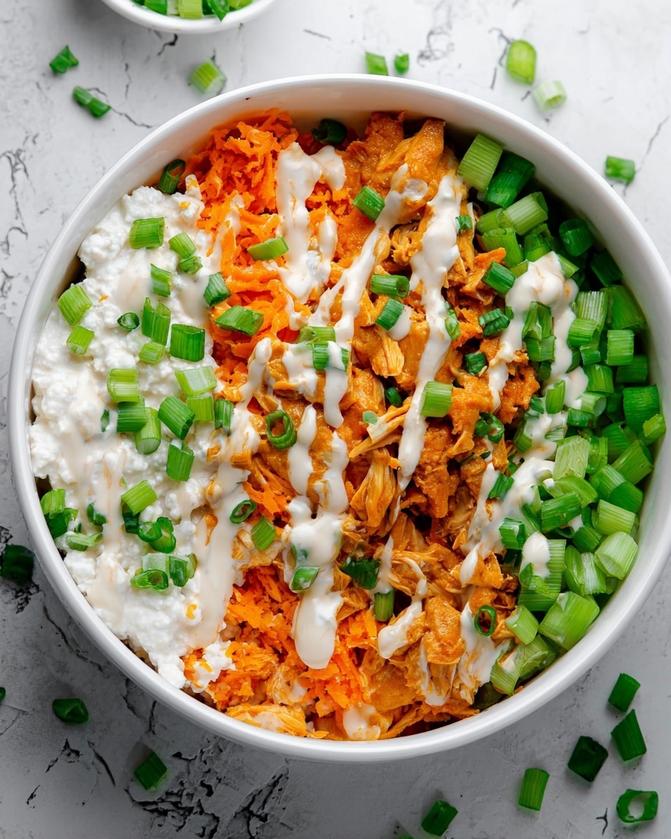 A white bowl filled with four layered ingredients arranged side by side: on the left, a thick white layer of cottage cheese topped with chopped green onions; next to it, bright orange shredded sweet potato mixed with slightly darker orange shredded chicken or meat, both drizzled with a creamy white sauce; on the right, chopped green celery pieces also covered with the same creamy sauce, and more chopped green onions scattered on top. The bowl sits on a white marbled surface with a few green onion pieces around it. photo taken with an iphone --ar 4:5 --v 7