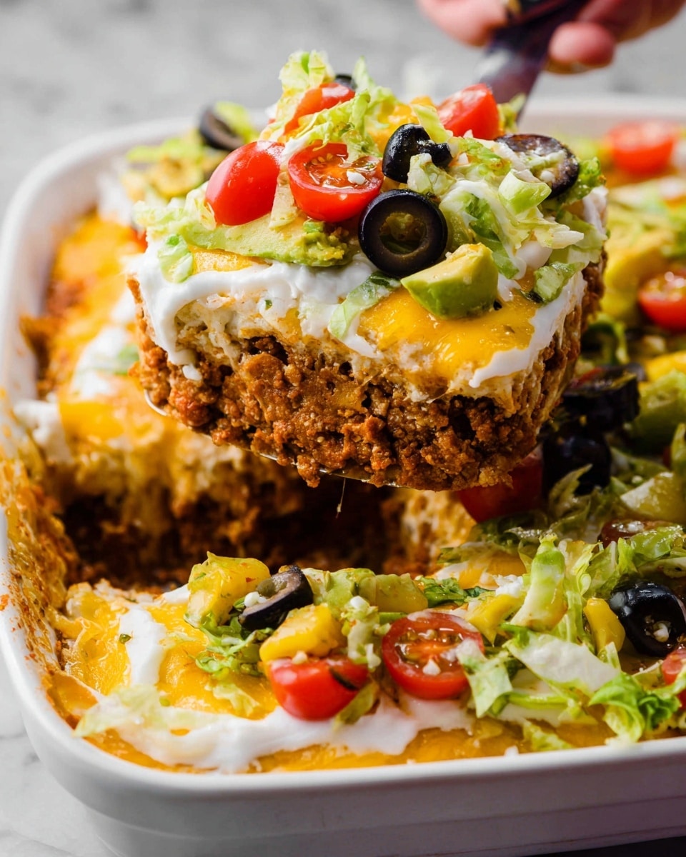 A close-up of a layered dish in a white deep dish, showing four main layers with toppings. The bottom layer is crumbly and brown, looking like cooked ground meat or beans. Above it is a smooth white layer that appears to be sour cream or a similar sauce. Next is a melted yellow cheese layer with bits of green lettuce mixed in. The top layer is a mix of fresh ingredients including black olive slices, avocado chunks, halved cherry tomatoes, shredded cheese, and bright green lettuce, arranged unevenly across the surface. A woman's hand with a spatula is lifting a square portion, showing the thickness and texture of the layers inside. The whole scene sits on a white marbled texture. photo taken with an iphone --ar 4:5 --v 7
