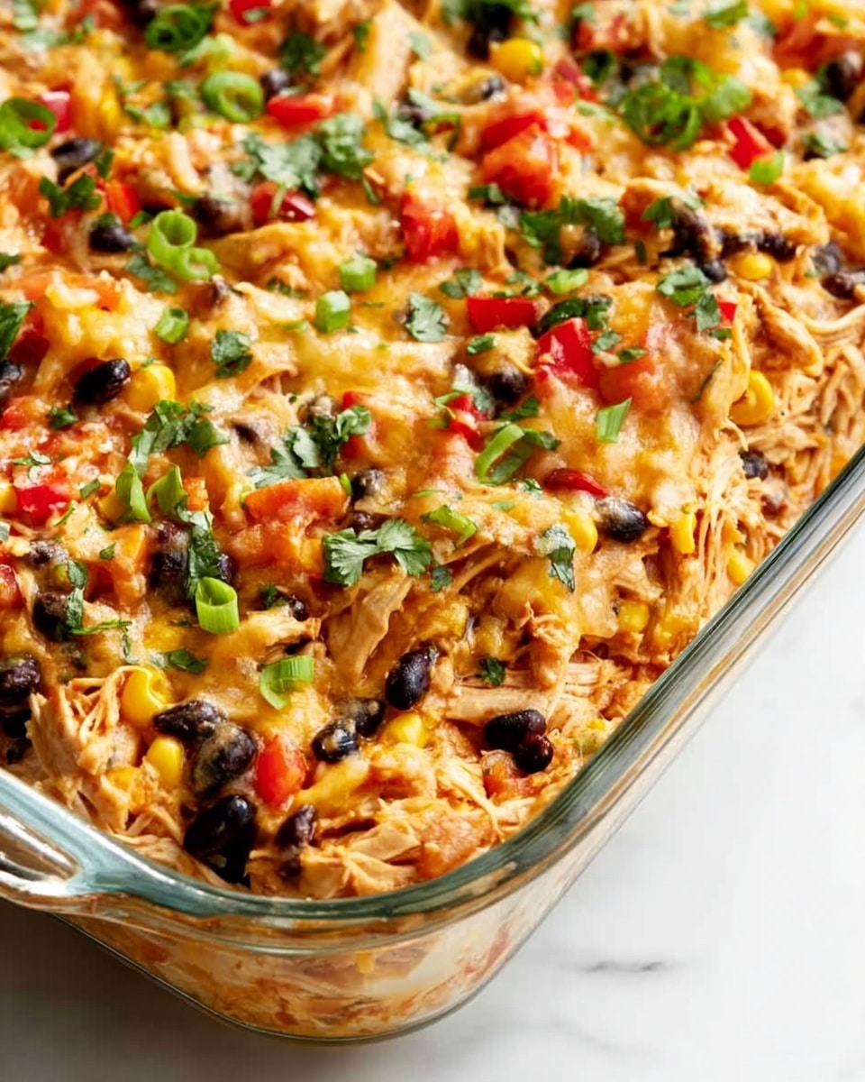 A white ridged plate holds a serving of a colorful dish with three main layers. The bottom layer is shredded light brown chicken mixed with small pieces of red bell pepper, black beans, and some green herbs, giving texture and color contrast. Scattered on top and around the chicken are bright chunks of green avocado, adding freshness. The top layer is a dollop of thick, creamy white sour cream placed in the center. A silver fork with a decorative handle rests on the left side of the plate. The plate sits on a white marbled surface. photo taken with an iphone --ar 4:5 --v 7