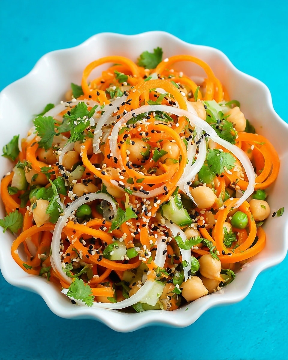 A white scalloped bowl filled with a fresh salad made of spiralized orange carrots and white onions twisted into thin curly strands mixed with chopped green bell peppers and whole round chickpeas. The salad is garnished with small green cilantro leaves and sprinkled with black and white sesame seeds and tiny chia seeds, all sitting on a bright blue background. photo taken with an iphone --ar 4:5 --v 7
