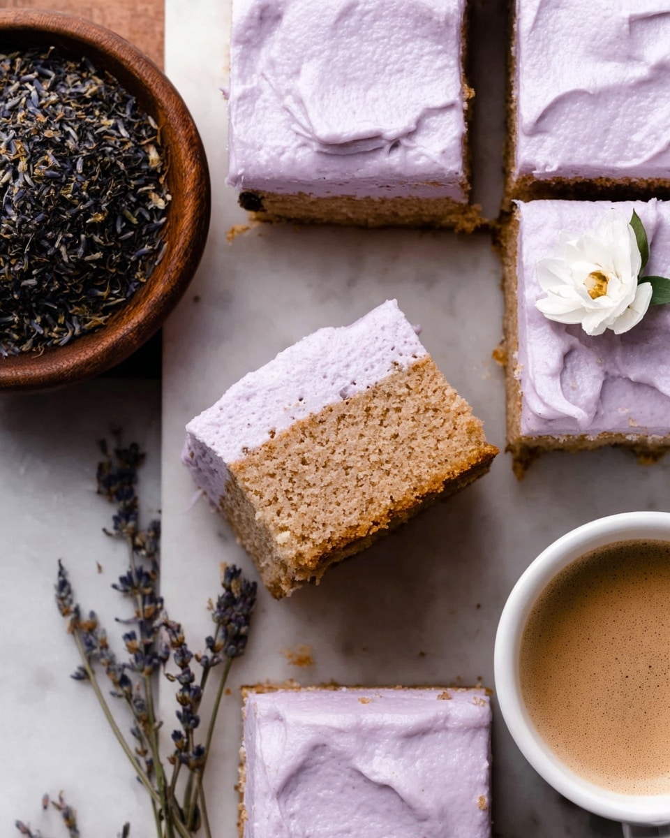 The image shows several square pieces of cake with one layer of light brown, grainy cake topped with a thick layer of pale purple frosting that has a slightly whipped texture. One piece is lifted, revealing the close-up texture of the cake and frosting. There is a wooden bowl filled with dried lavender and tea leaves on the left side, and a white cup with frothy light brown coffee or tea on the bottom right. The items rest on a white marbled surface. One cake piece is decorated with a small white flower and a sprig of dried lavender nearby. Photo taken with an iphone --ar 4:5 --v 7