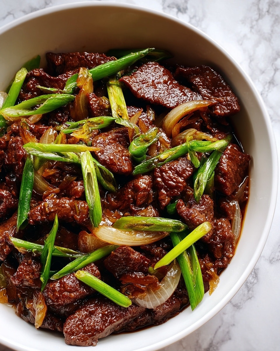 A close-up image of a white bowl filled with cooked beef chunks that are dark brown and glossy, mixed with cooked onion pieces that are translucent and slightly browned. On top, there are bright green sliced scallions scattered evenly, adding a fresh look. The bowl sits on a white marbled surface, and the focus is on the rich texture of the beef and the fresh green toppings. photo taken with an iphone --ar 4:5 --v 7